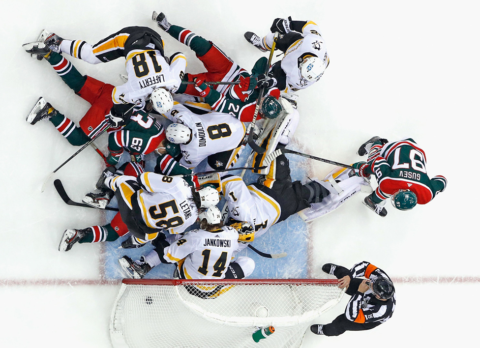 Hokejaši Pitsburg Pingvina brane se od napada domaćih Nju Džersi Devilsa u trećoj trećini meča Nacionalne hokejaške lige Amerike